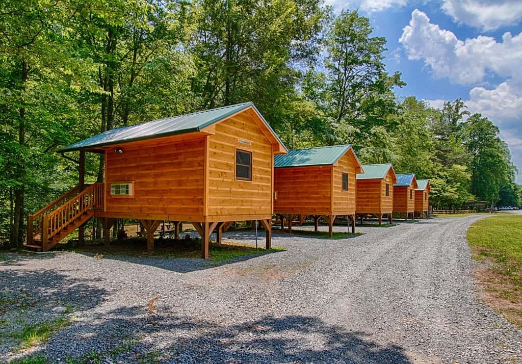 5 small cabins in a row facing the river at Pigeon River Campground in the Smoky Mountains