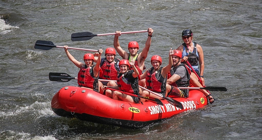 A happy group of people white water rafting near Gatlinburg at Smoky Mountain Outdoors.