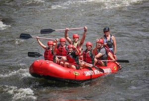 A happy group of people white water rafting near Gatlinburg at Smoky Mountain Outdoors.