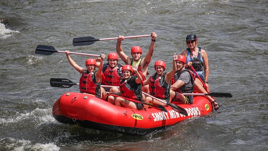 A happy group of people white water rafting near Gatlinburg at Smoky Mountain Outdoors.
