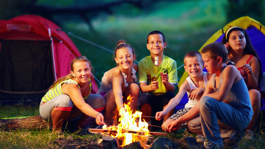 A group of kids sitting around the campfire on a Smoky Mountain camping trip.
