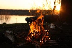 A campfire beside a riverbank.
