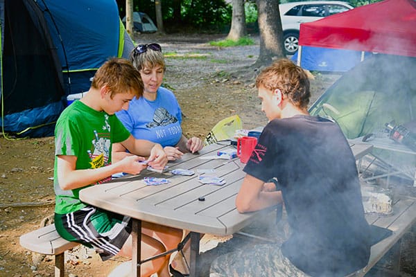 Family playing cards at campsite