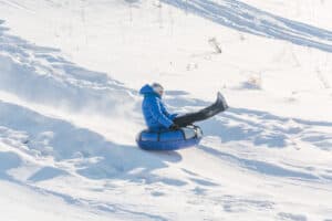 person snow tubing down hill